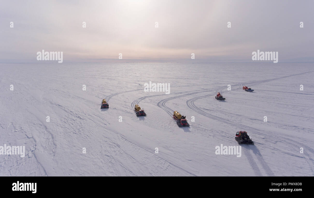 Un groupe de motoneiges est marcher le long de la plaine enneigée. Convoi de la neige. L'antarctique. Vue de dessus. Banque D'Images