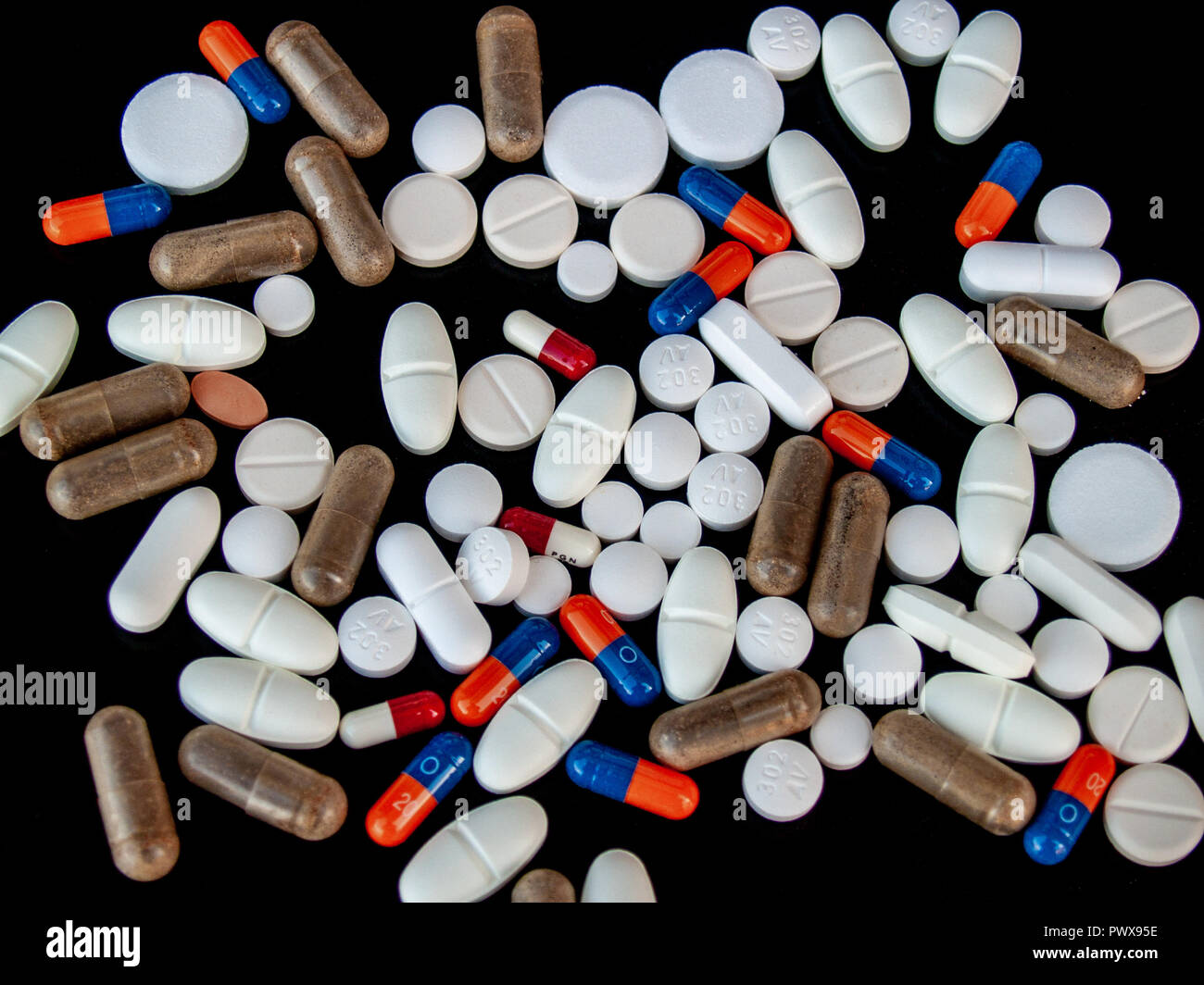 Comprimés de différentes tailles, formes et couleurs sur fond noir. Concept de santé Banque D'Images