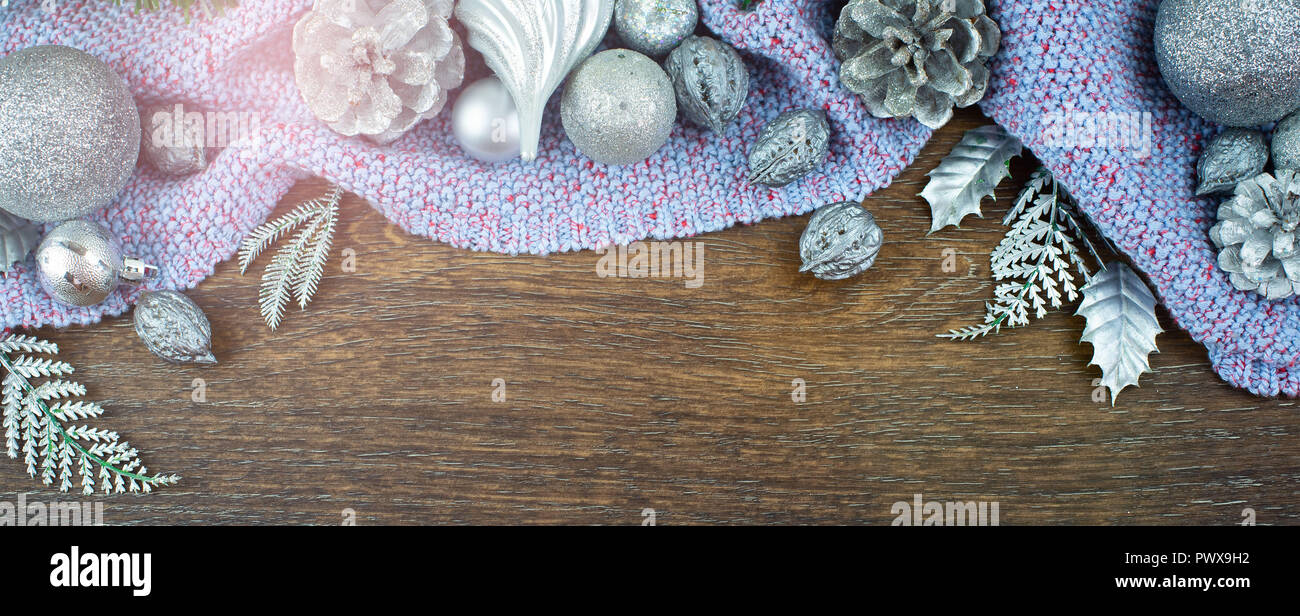 Composition de Noël bannière balles brillants branches cônes noix feuilles en bois de cèdre d'argent sur fond sombre plaid violet. Vue supérieure mise à plat f sélective Banque D'Images