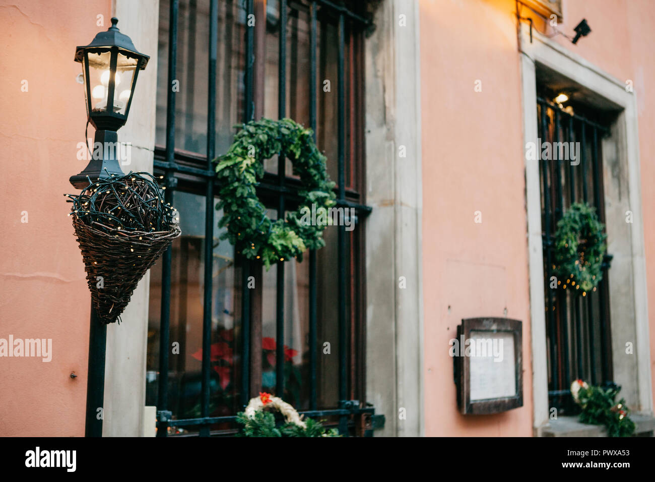 Décorations de Noël traditionnel à l'extérieur de la cafe à Varsovie. Des  couronnes de Noël sur les fenêtres décorées et lampadaire de guirlandes  près du bâtiment Photo Stock - Alamy