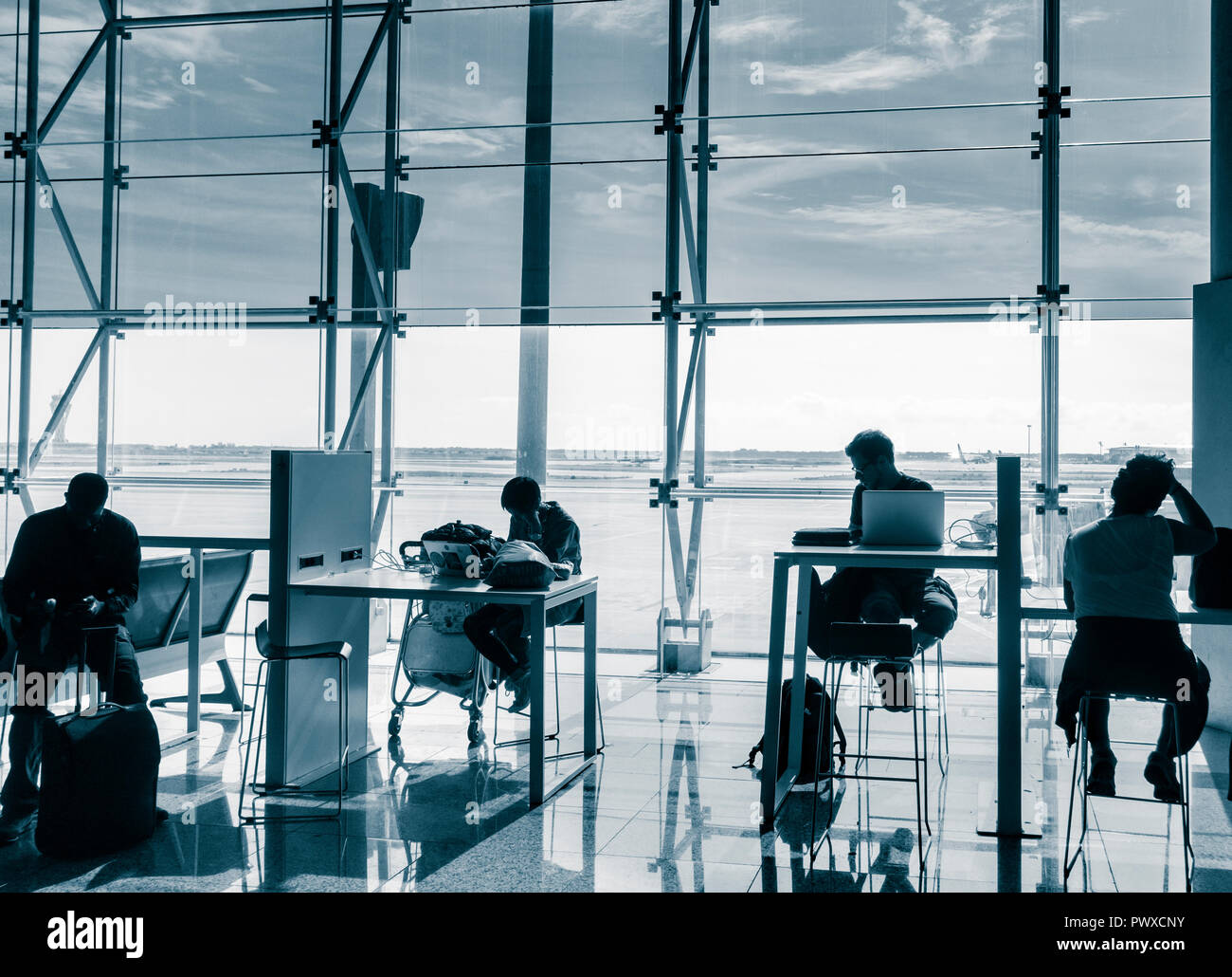 Les personnes qui utilisent les appareils mobiles et ordinateurs portables dans la zone Wifi à l'aéroport El Prat de Barcelone. Espagne Banque D'Images