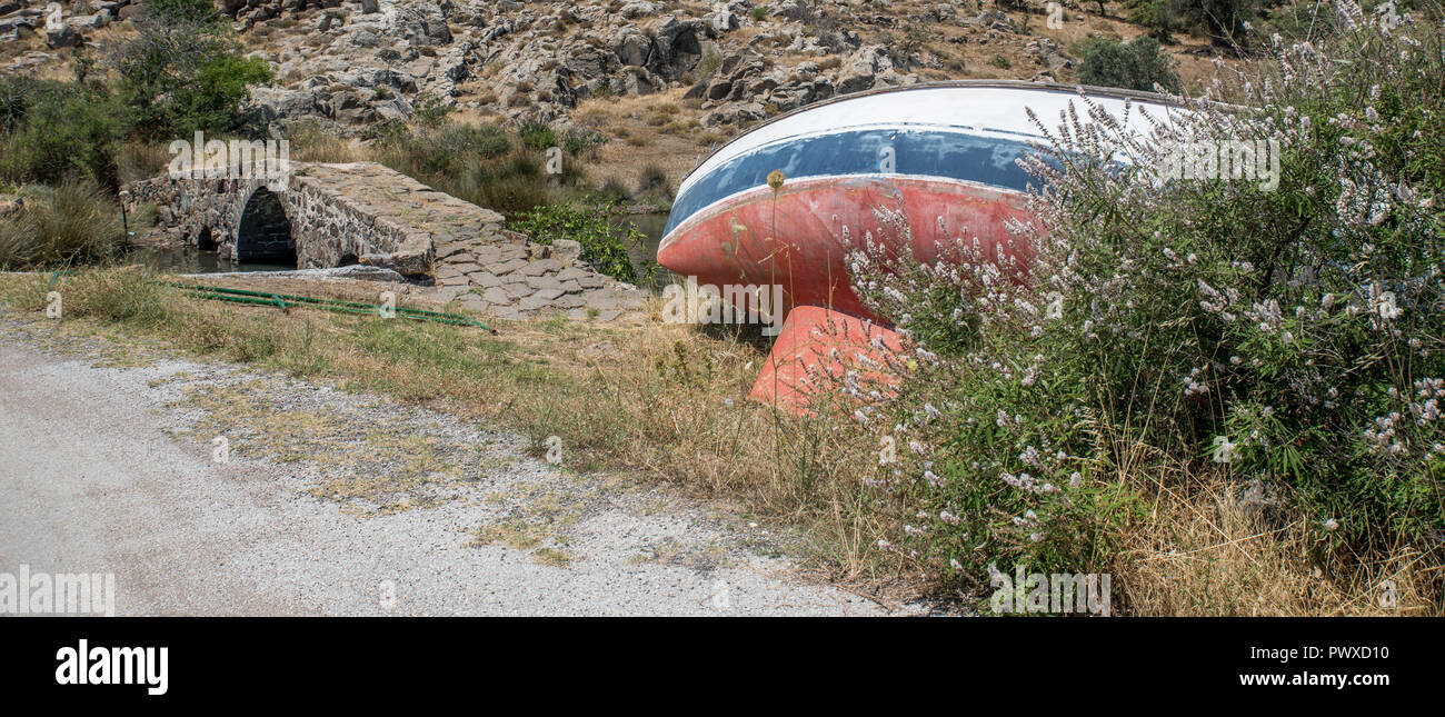 Voilier abandonné sur la plage près de l'ancien pont Banque D'Images Voilier abandonné sur la plage près de l'ancien pont Banque D'Images