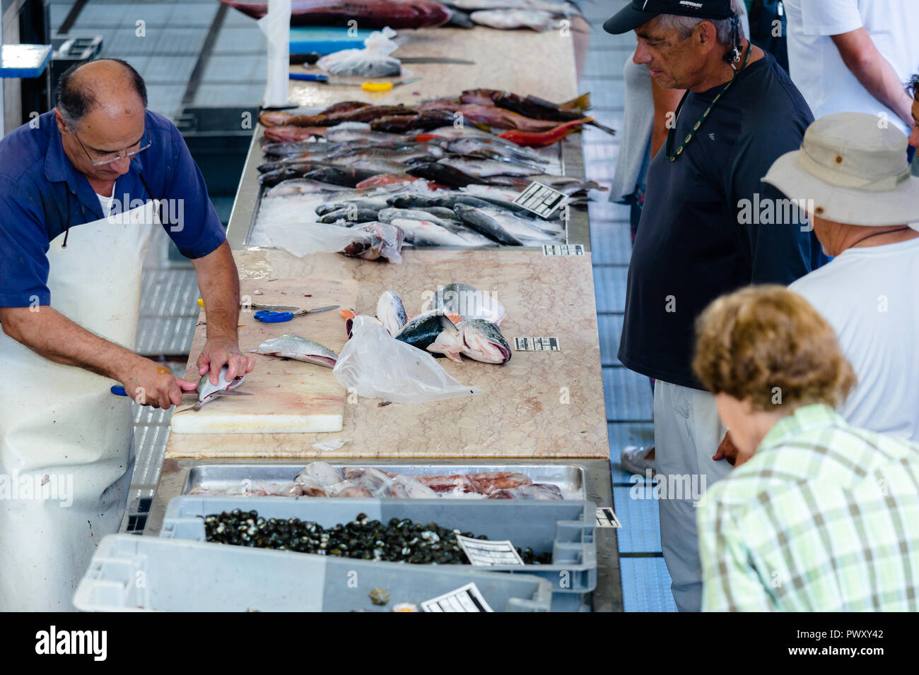 Poissonnier à la vente du poisson à 'Mercado DOS Lavradores', l'île de Madère. Portugal, Octobre 2018. Banque D'Images