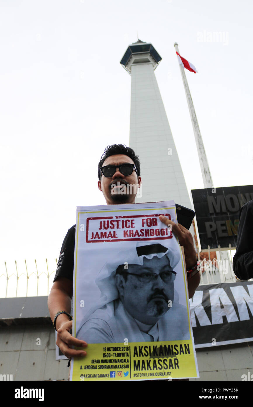 À Makassar, Indonésie. 18 Oct 2018. Une activiste humanitaire est titulaire d'une affiche avec l'image de Jamal Khashoggi démontrent à l'avant du monument, Mandala Makassar. Jamal Khashoggi, un journaliste saoudien qui aurait été tué et mutilé tout en Arabie consulat à Istanbul, Turquie. La manifestation qui a eu lieu dans la région de Makassar a également appelé la communauté internationale à mener une enquête approfondie sur le meurtre du journaliste. Credit : Herwin Bahar/Alamy Live News Banque D'Images