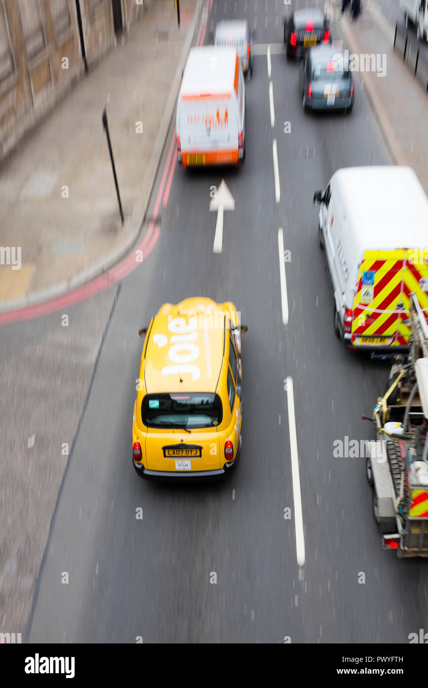 Londres, Royaume-Uni. Un taxi jaune est vu de dessus en passant sous un pont. Banque D'Images