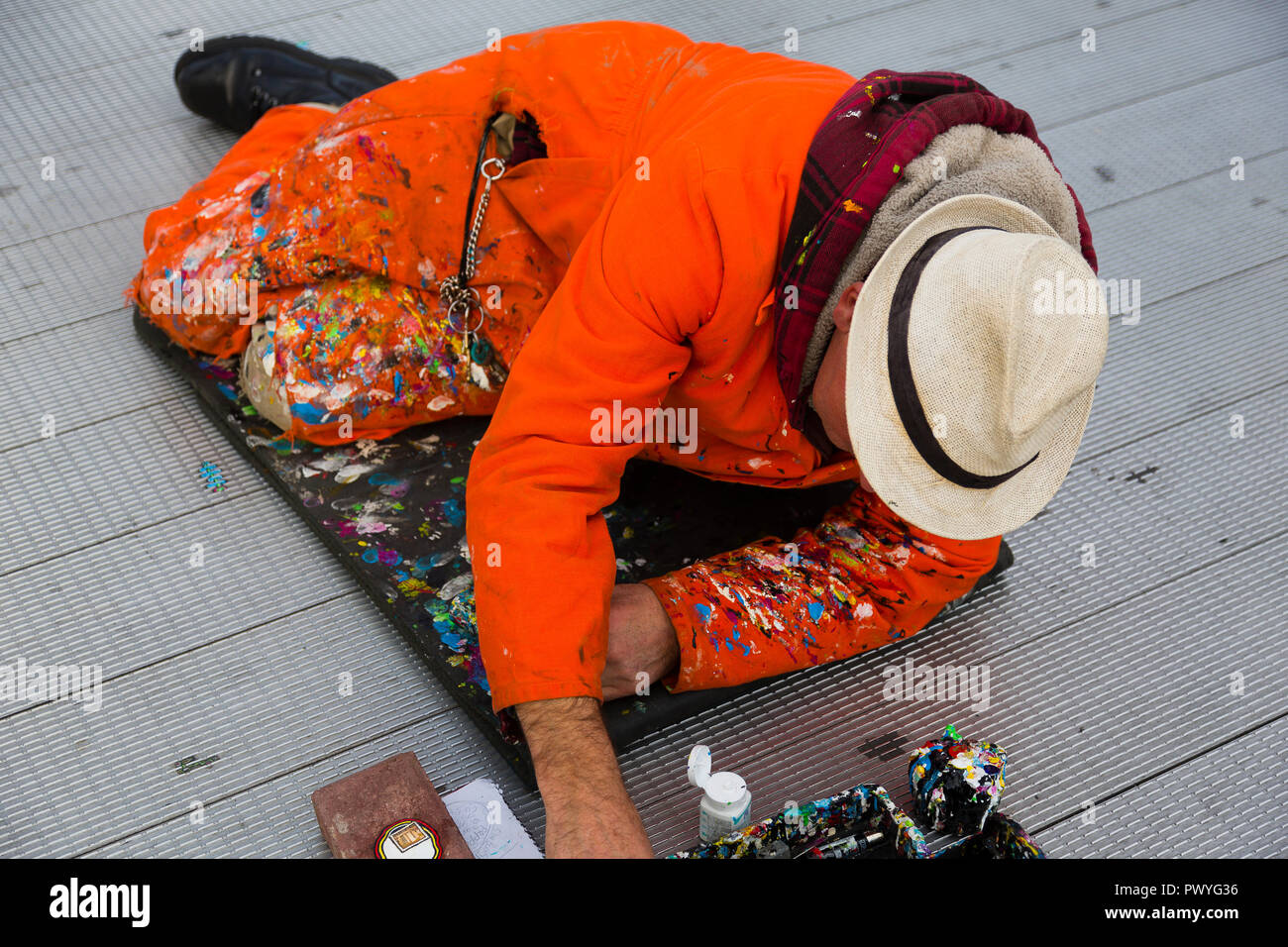 Londres, Royaume-Uni. Ben Wilson se trouve sur le plancher de la Millenium Bridge comme il remplit un petit morceau d'art sur un morceau de chewing-gum. Banque D'Images