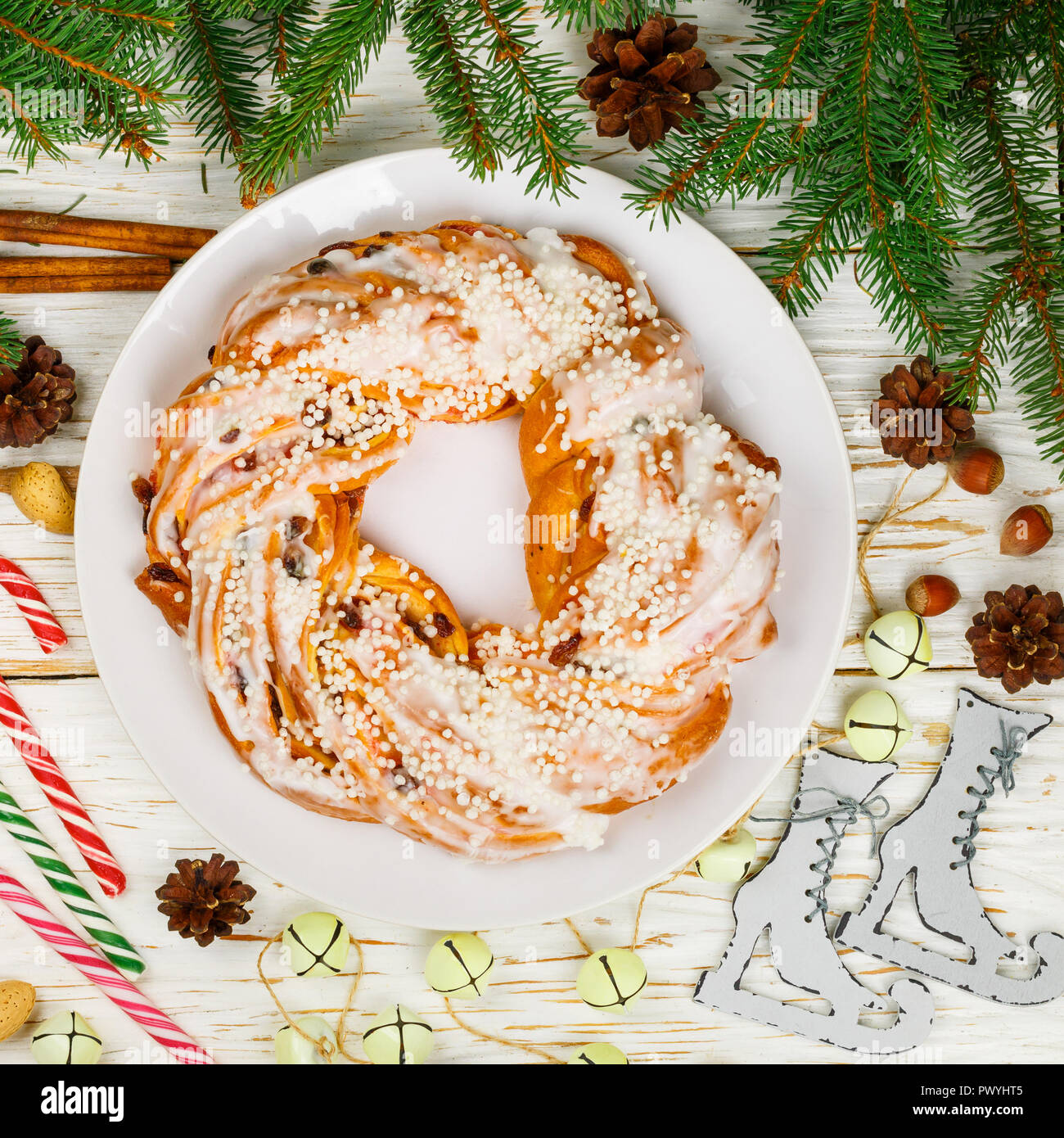 Nouvelle année (Noël) gâteau à la cannelle, les amandes, les noisettes et les canneberges sèches. roll crunch recouvert de sucre glace. Traiter de fête pour plateau carré. Banque D'Images