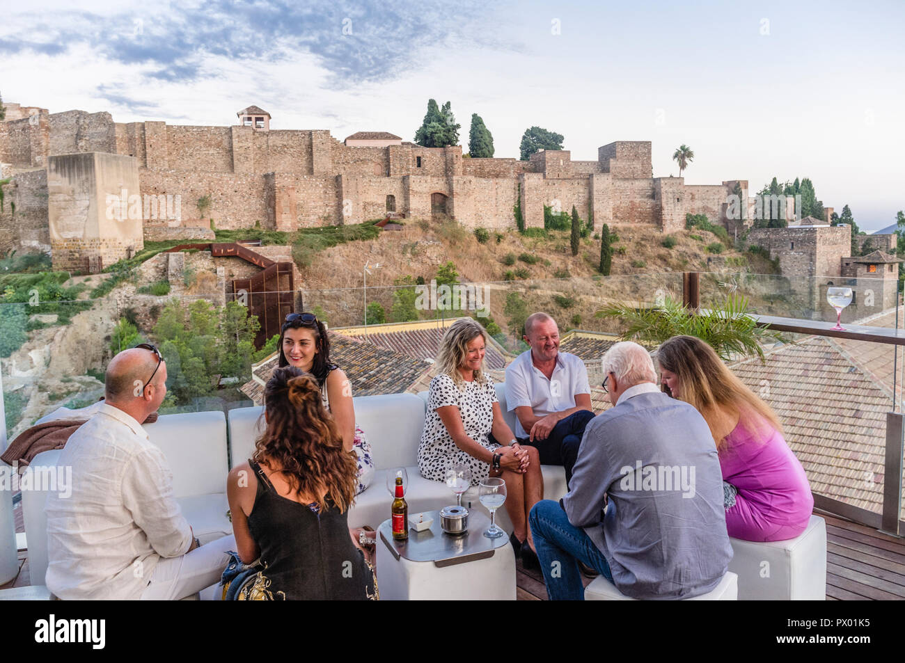Les gens avec l'Alcazaba château en arrière-plan au bar-salon sur le toit de l'Alcazaba Premium Hostel, Malaga, Andalousie, espagne. Banque D'Images