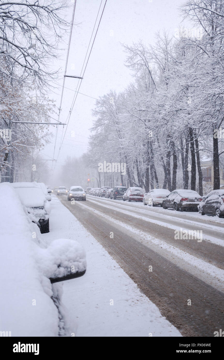 Ville couverte de neige avec de la route conduire des voitures et wagons couverts de neige sur la route lors de chutes de neige. Banque D'Images