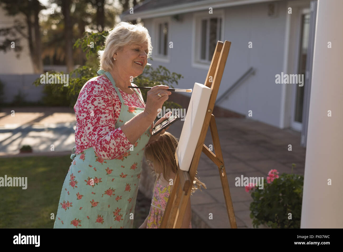 Senior woman painting on canvas dans le jardin Banque D'Images