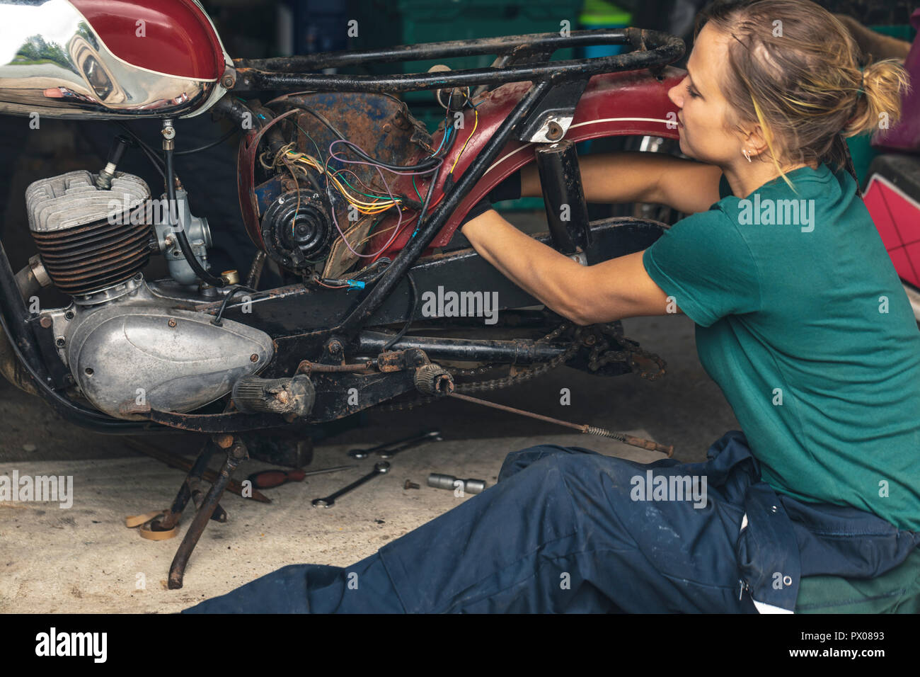 Femme mechanic repairing moto dans garage Banque D'Images