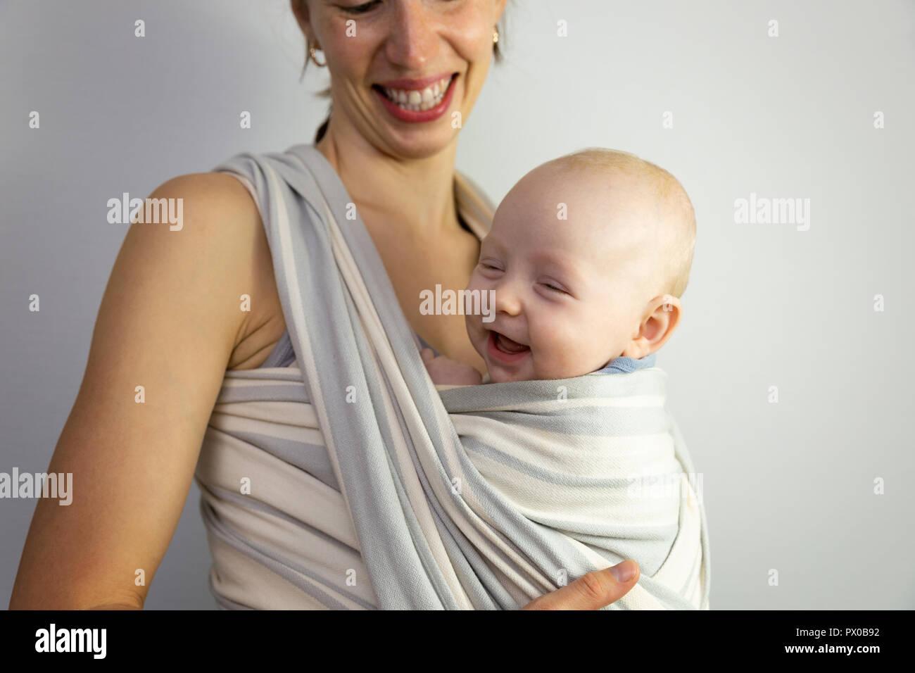Heureux le bébé et la mère. Près de mère bébé dans une écharpe. Banque D'Images