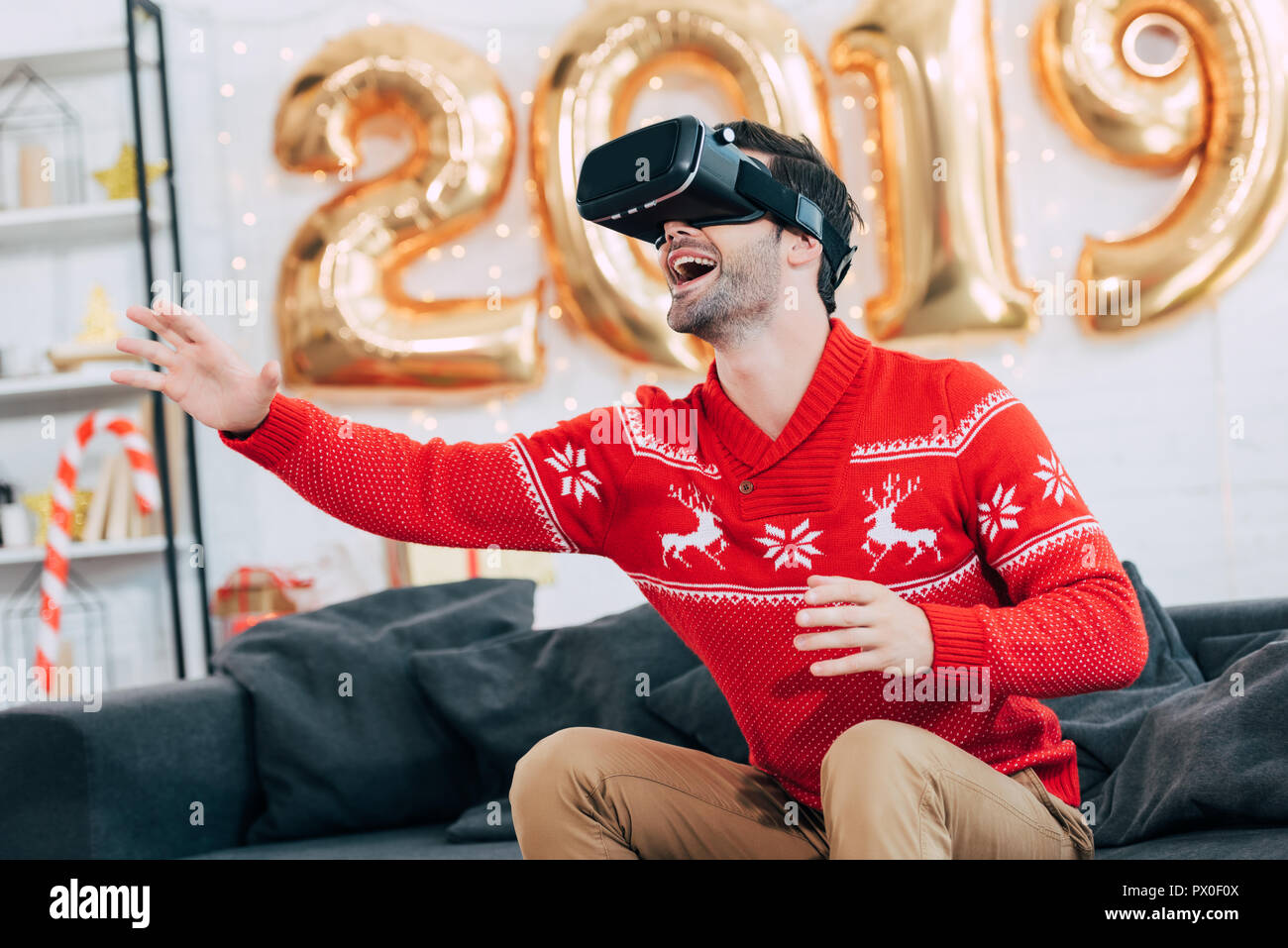 Man gesturing excité et l'utilisation de casque de réalité virtuelle au cours de la nouvelle année 2019 Banque D'Images