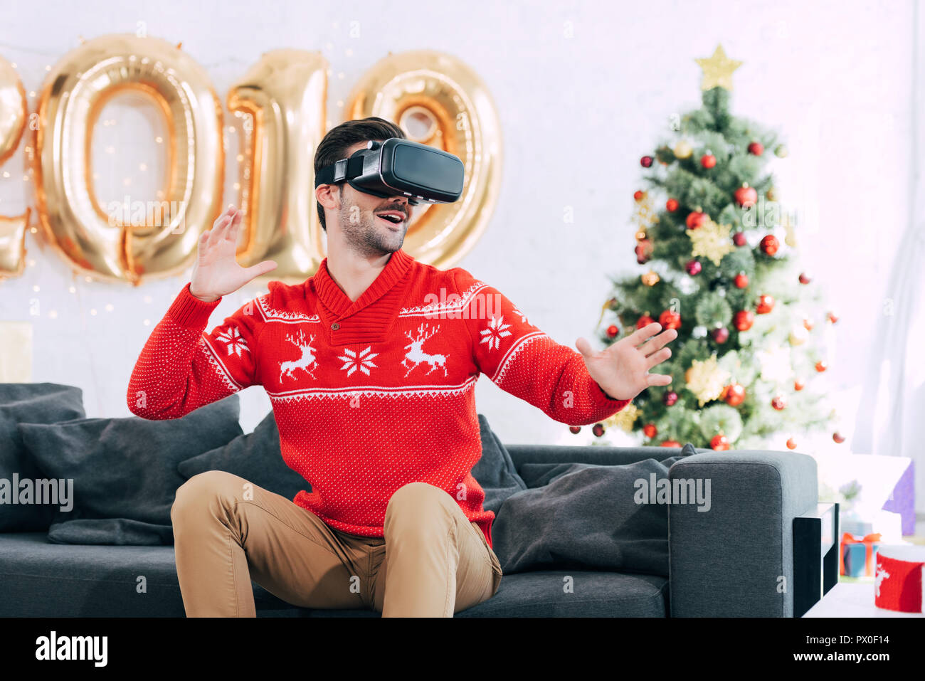 Smiling man à l'aide de casque de réalité virtuelle au cours de la nouvelle année 2019 Banque D'Images
