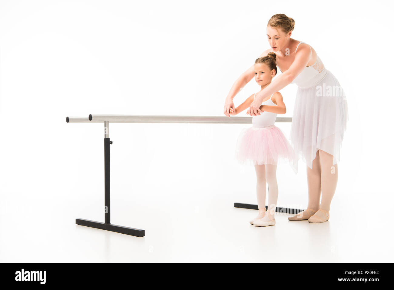 Enseignante en tutu ballerine aidant les petits à la pratique de la barre de ballet stand isolé sur fond blanc Banque D'Images