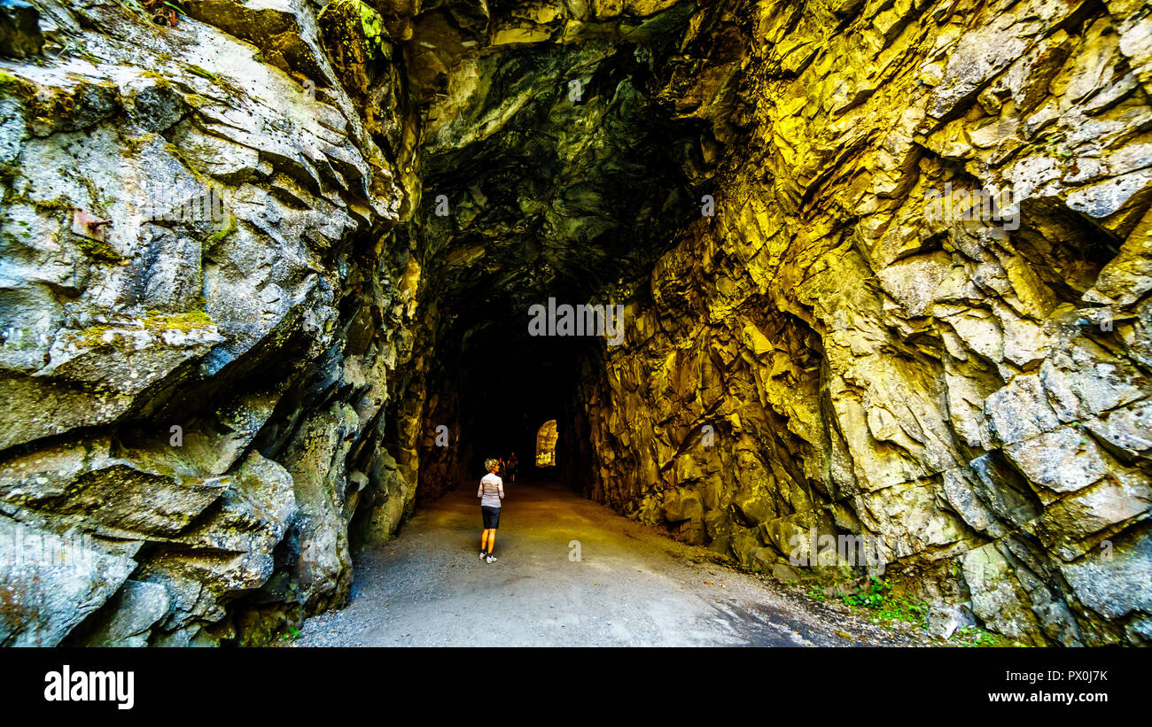 Les touristes marche dans les tunnels d'Othello qui ont été sculptés par la Coquihalla Canyon pour le chemin de fer de Kettle Valley maintenant abandonnée à Hope, C.-B., Canada Banque D'Images