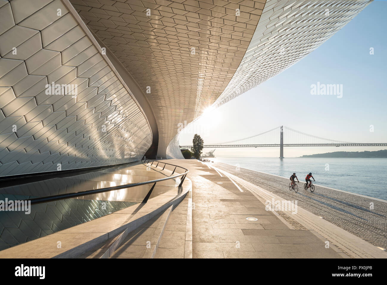 Vue extérieure de la MAAT - Musée d'art, d'architecture et de la Technologie, Lisbonne, Portugal. Les cyclistes sur les berges. Banque D'Images