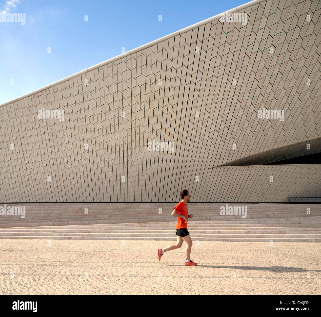 Vue extérieure de la MAAT - Musée d'art, d'architecture et de la Technologie, Lisbonne, Portugal. Homme jogger passé en courant. Banque D'Images