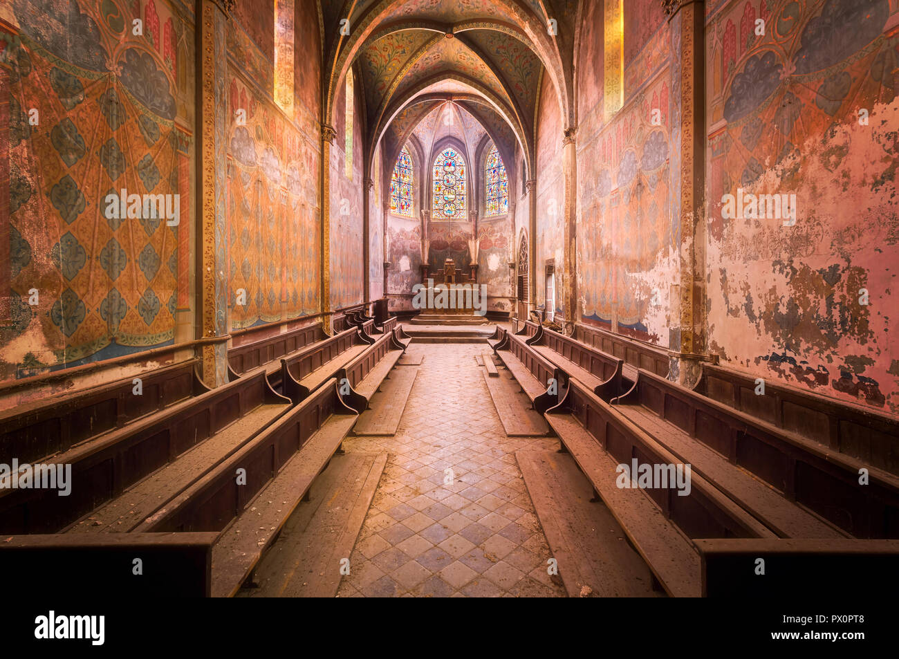 Vue intérieure d'une église abandonnée en France avec de belles couleurs rose. Banque D'Images