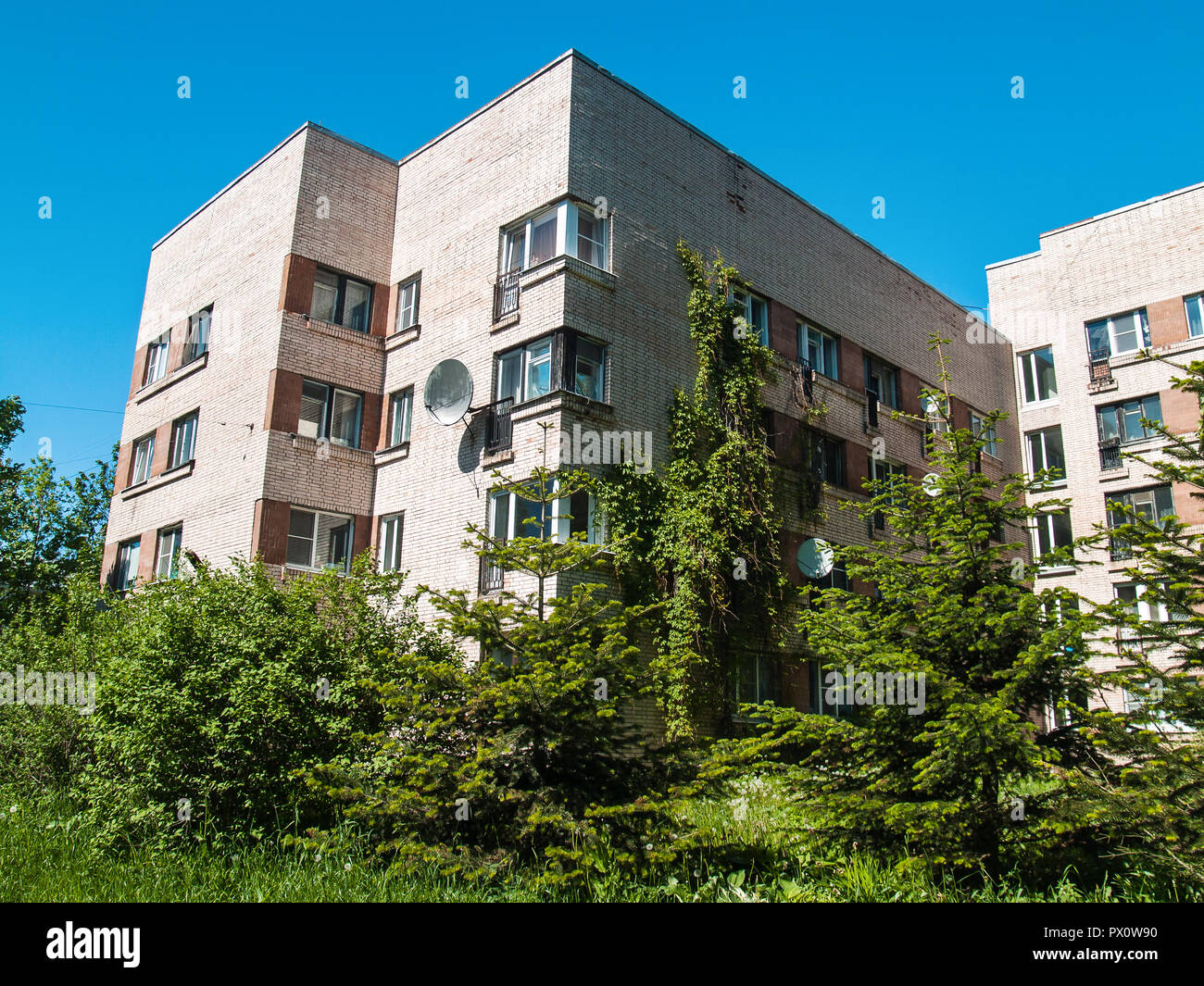 Une maison de 5 étages en brique de lumière contre un ciel bleu avec des fleurs luxuriante verdure près du sous-sol à Saint-Pétersbourg dans Tsarskoïe Selo Banque D'Images