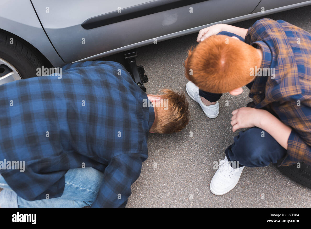 Portrait du père et fils de voiture avec un cric de levage pour changement de pneu Banque D'Images