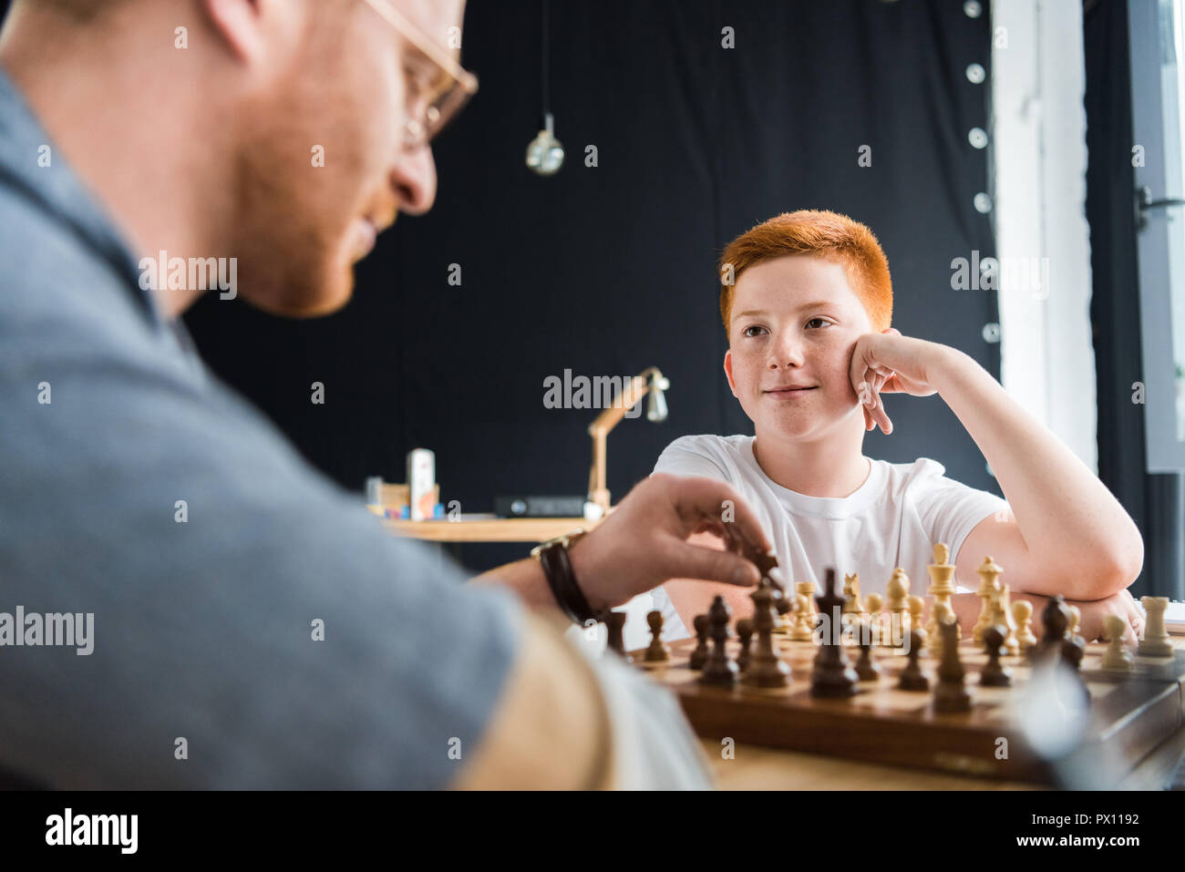 Son père jouer aux échecs à la maison Banque D'Images