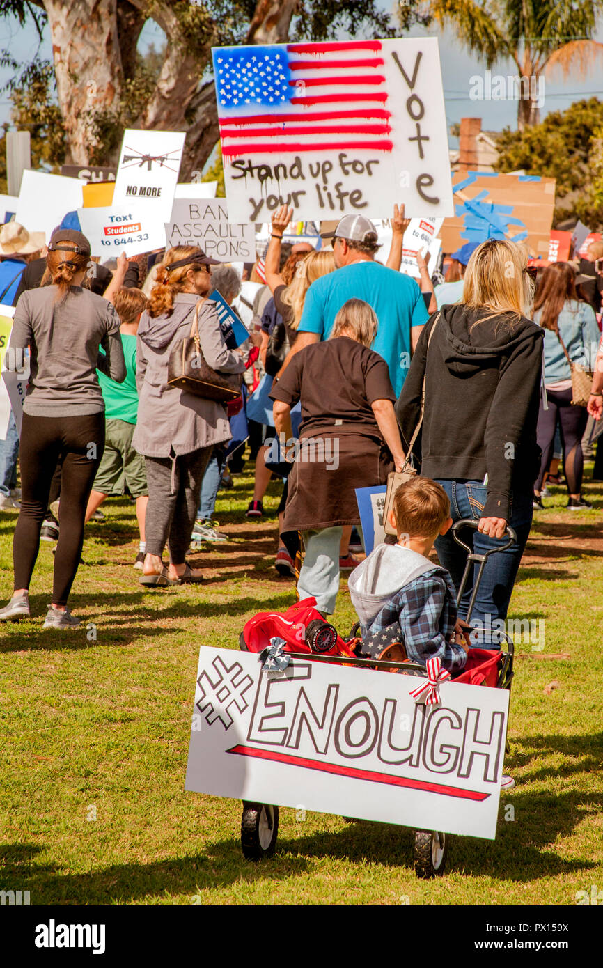Un garçon porte un signe en faveur du contrôle des armes à feu comme protestataires manifester dans un Long Beach, CA, parc municipal. Banque D'Images