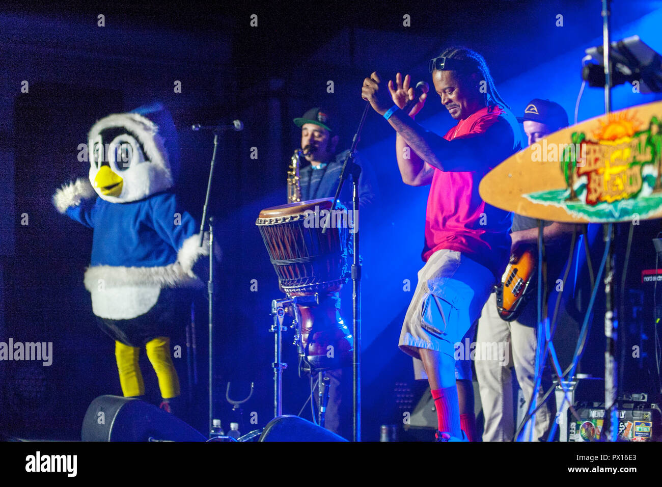 Un groupe de rock 'n roll singer dans un costume de pingouin est une mascotte de la bande lors d'un concert du festival de la communauté à Costa Mesa, CA. Banque D'Images