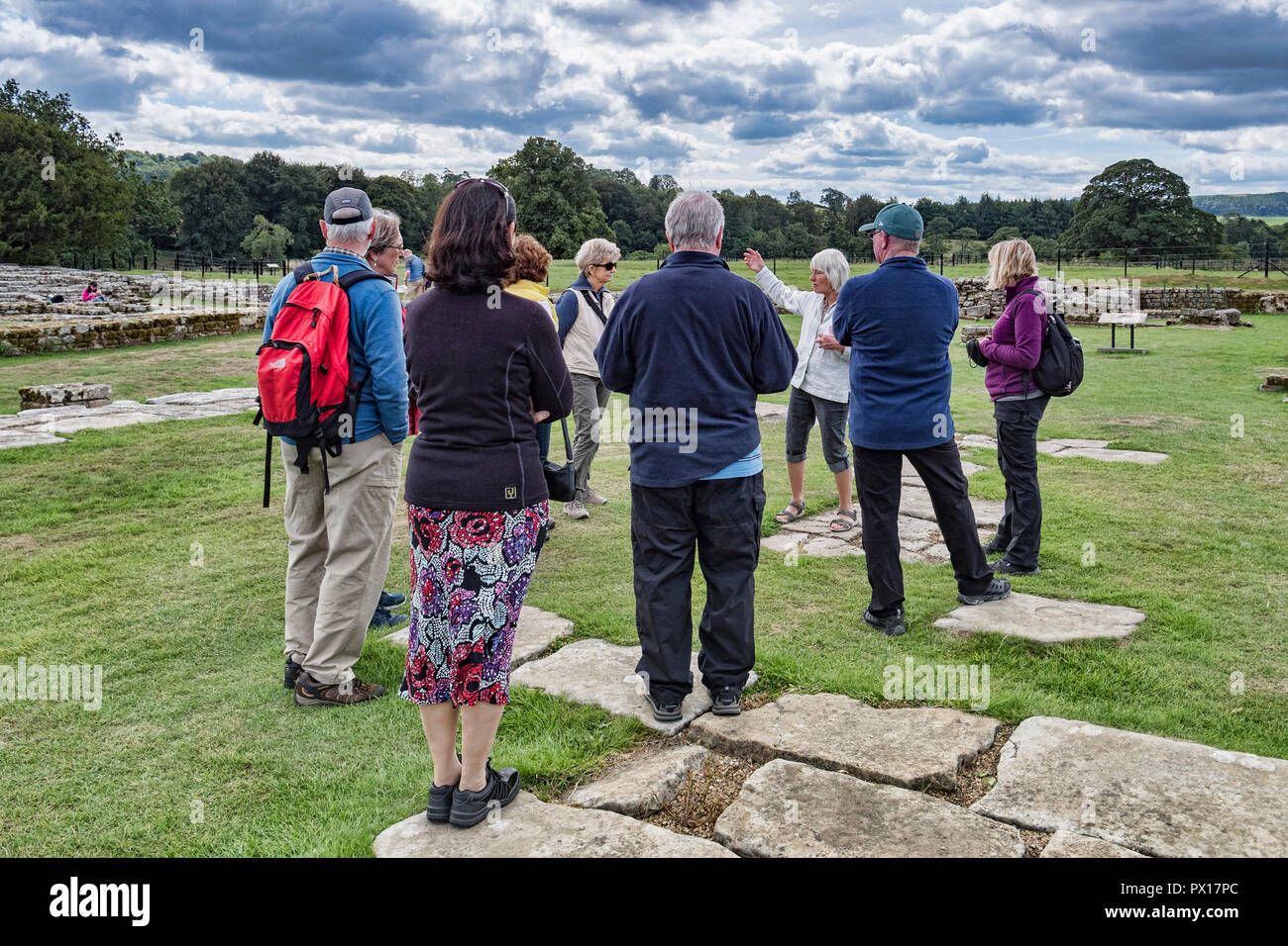 11 Août 2018 : NORTHUMBERLAND, UK - Les visiteurs de l'écoute d'un guide sur un tour au Fort romain de Chesters, mur d'Hadrien, Northumberland, Angleterre Banque D'Images