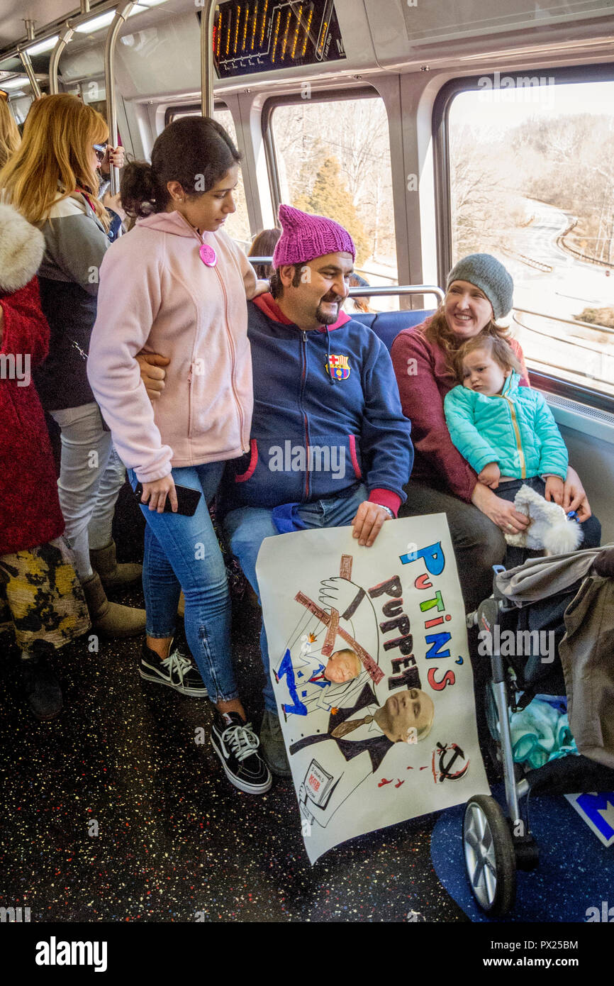 Portant un signe de protestation politique faits maison, un père et sa fille prendre le Washington, DC Metro train pour une démonstration du centre-ville. Banque D'Images