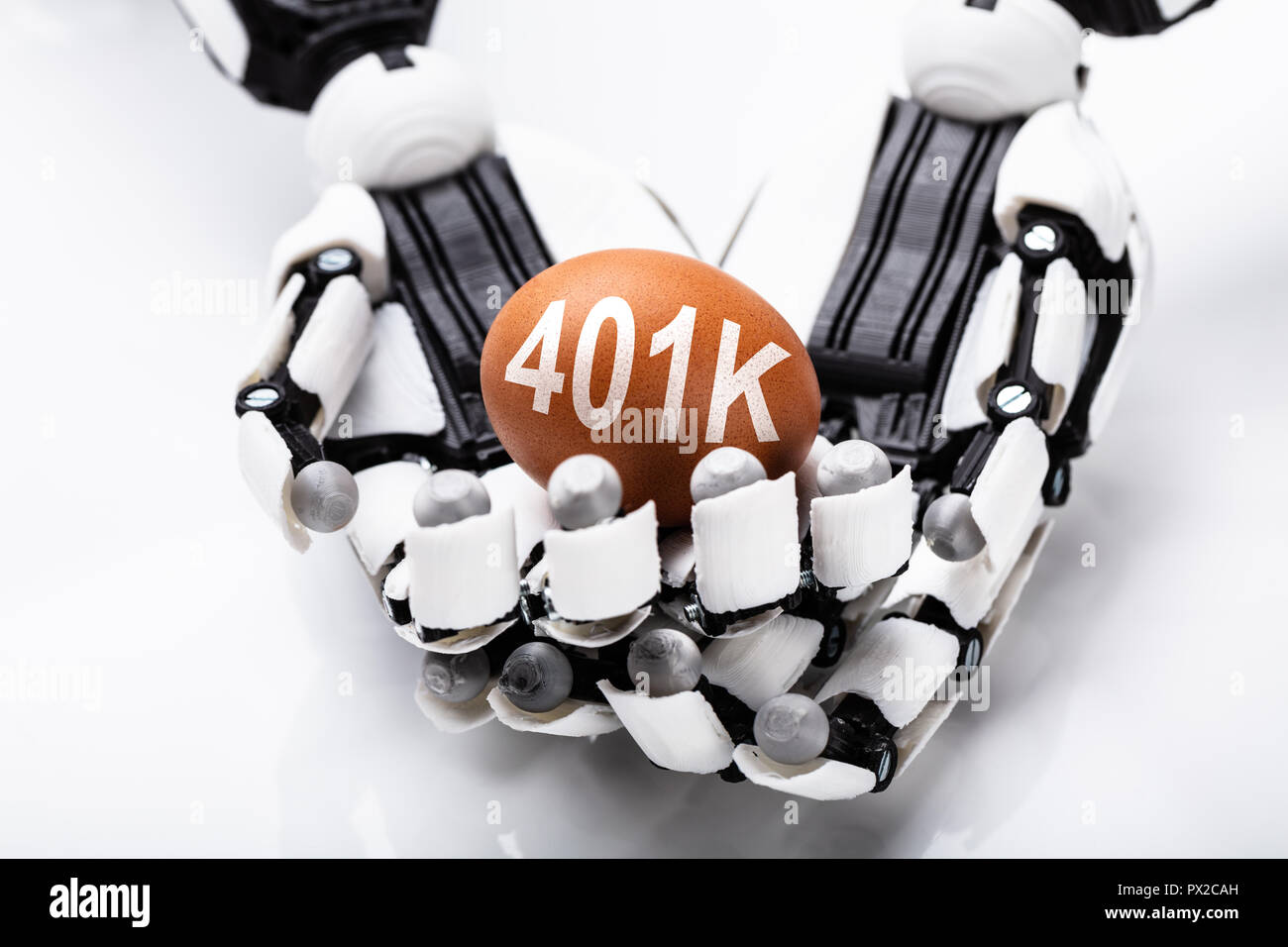 Close-up of Robot Holding Brown Egg 401k sur fond blanc Banque D'Images