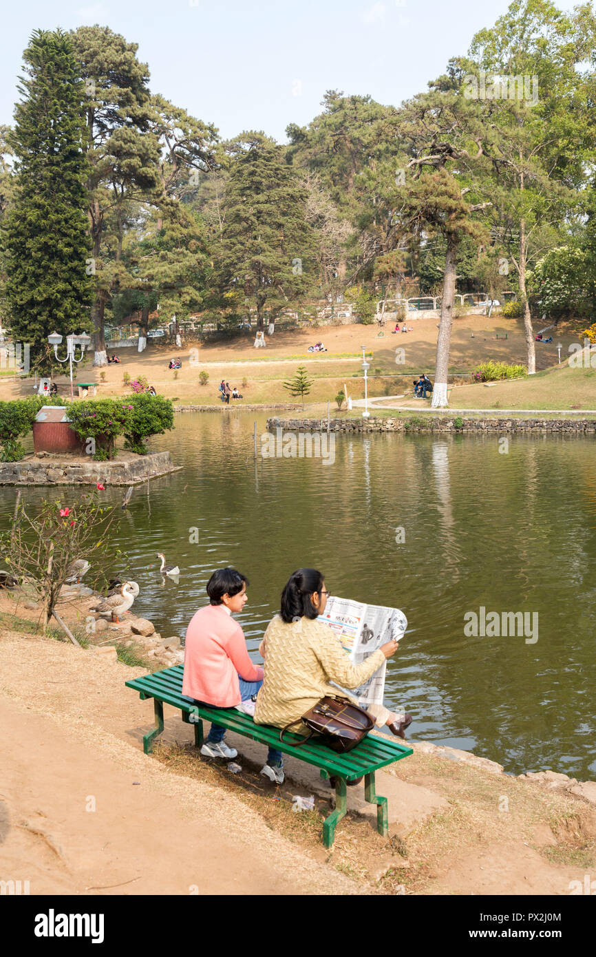 Les gens de lire le journal dans le parc à Ward's Lake, Shillong, Meghalaya, en Inde Banque D'Images