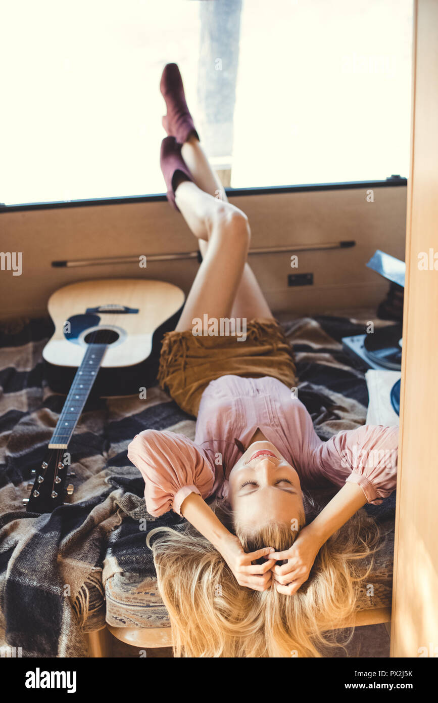 Girl relaxing hippie avec remorque à l'intérieur de la guitare acoustique et de lecteur de vinyle Banque D'Images