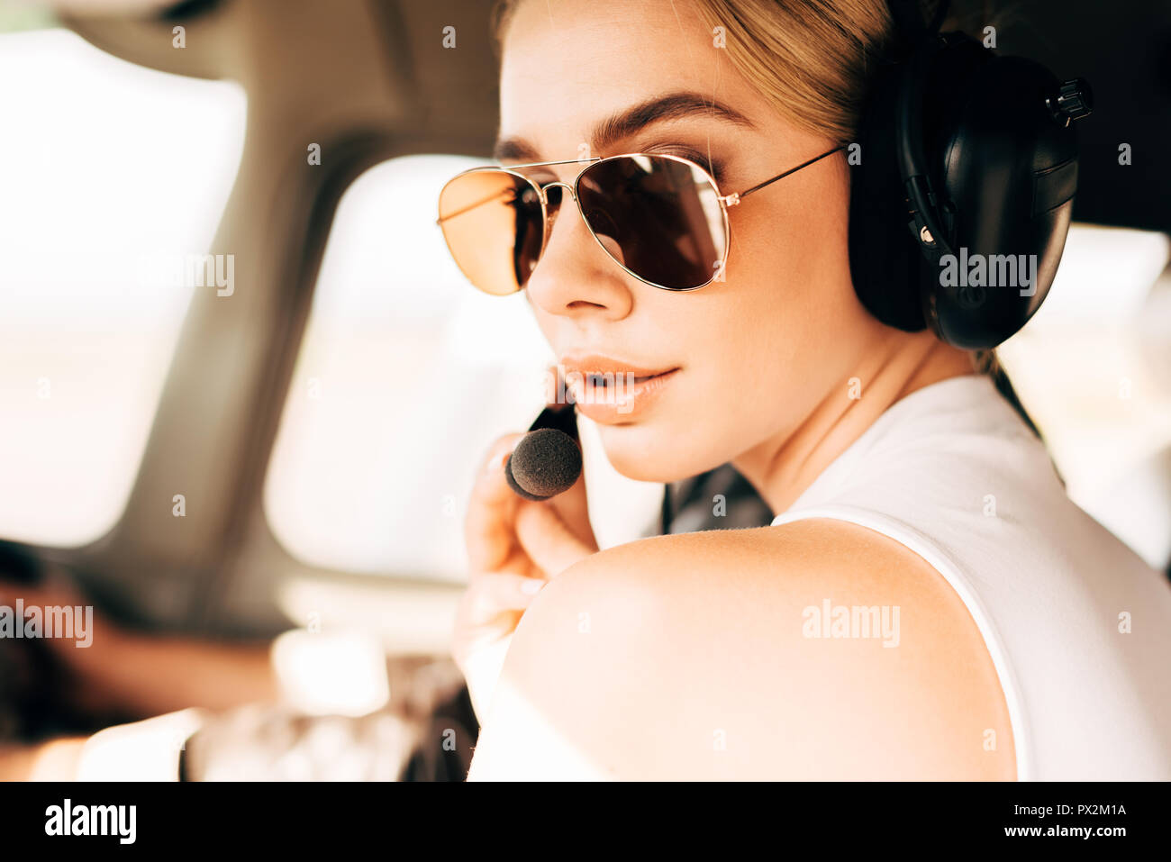 Close up portrait of attractive woman with headset looking at camera in airplane Banque D'Images