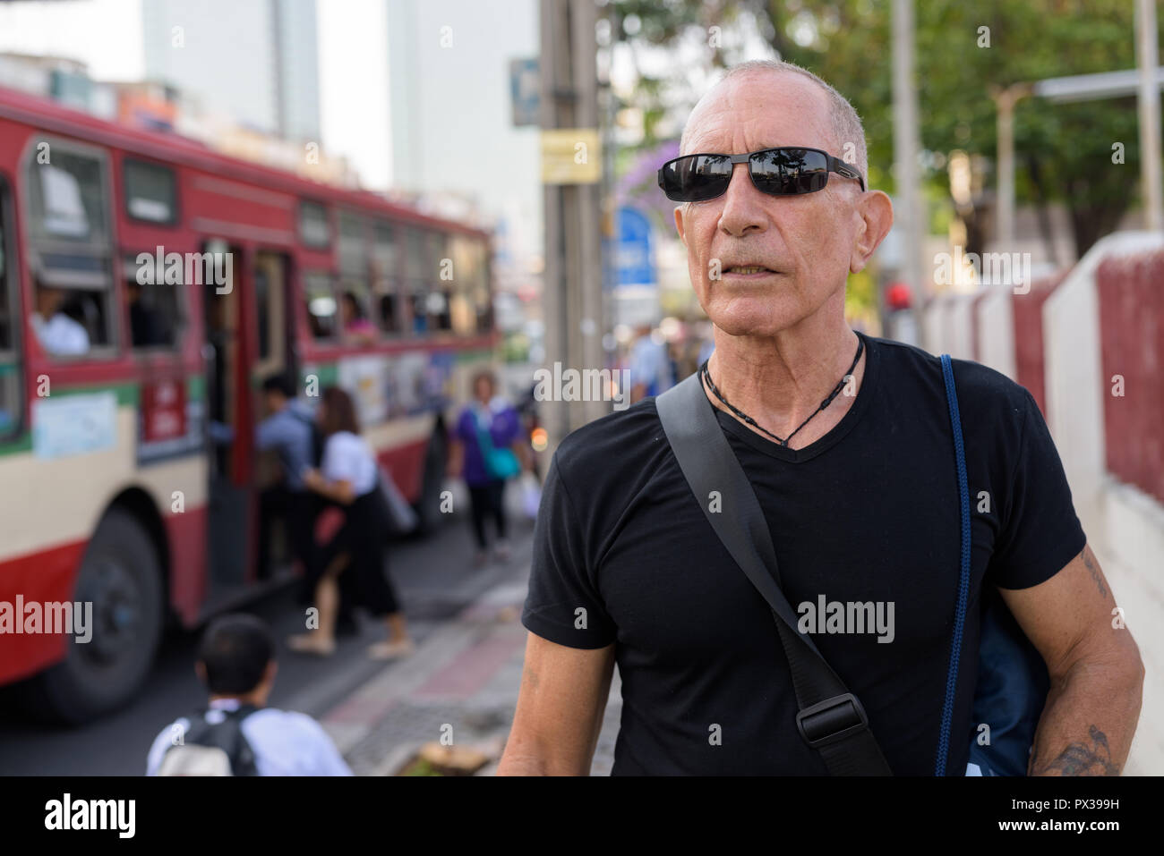 Senior homme chauve touristique pensée tout en portant des lunettes de soleil à la Banque D'Images
