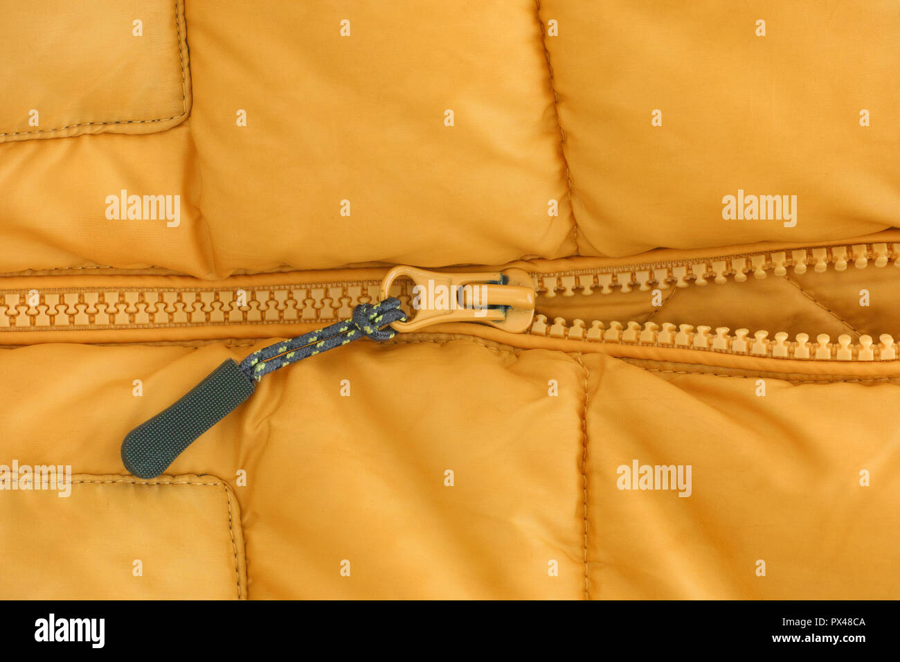 Photo de gros plan d'une fermeture éclair sur une veste jaune. Close up. Banque D'Images