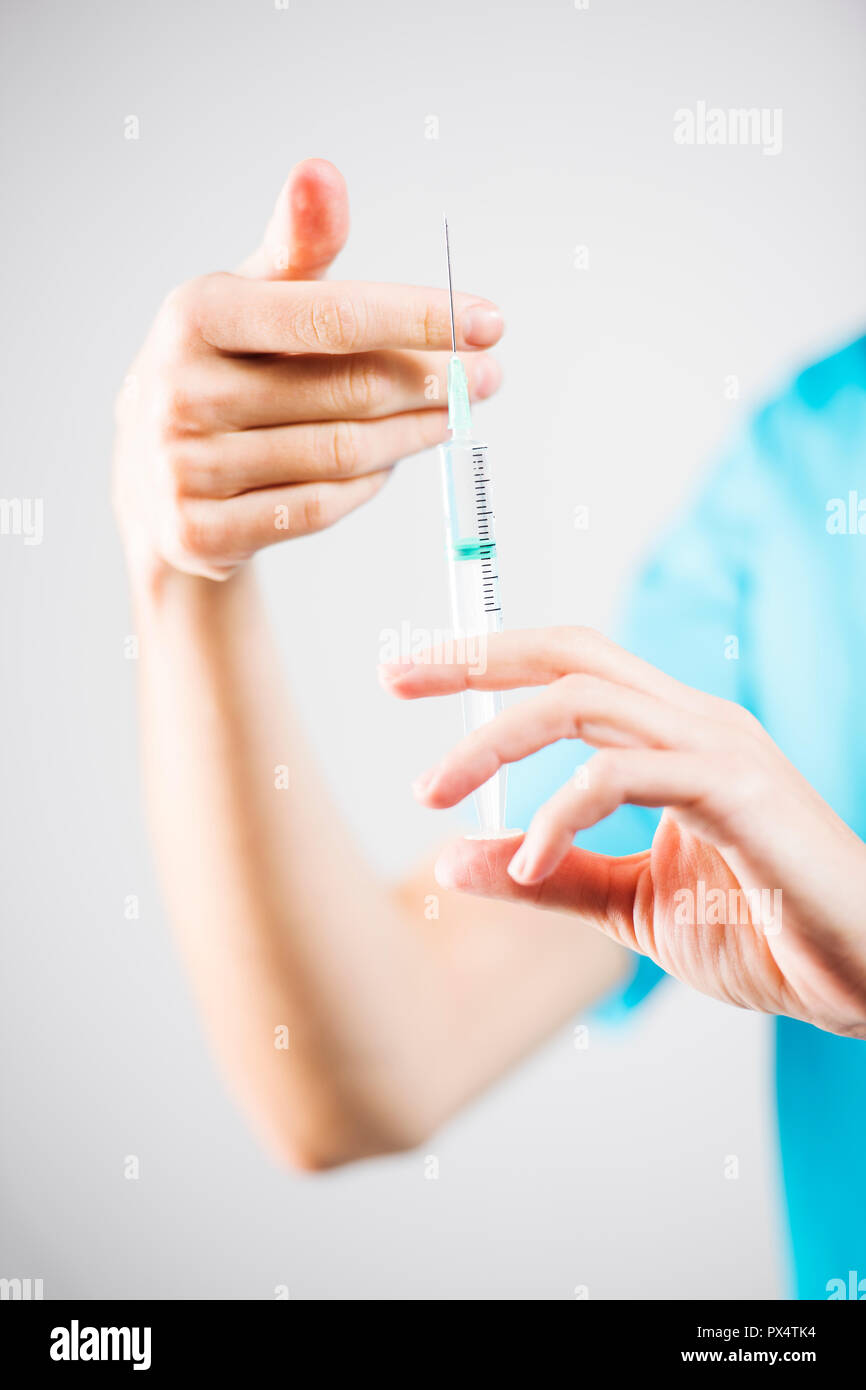 Femme de l'infirmière ou du médecin s'appuyant sur une seringue de la préparation à l'injection Banque D'Images