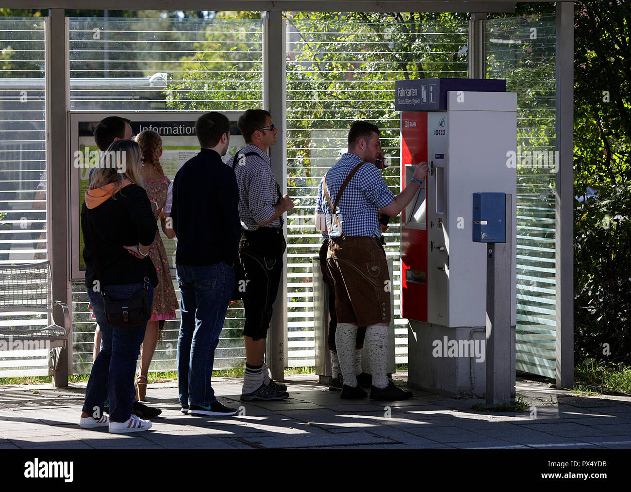 Les fêtards Oktoberfest à l'obtention de tickets station Riem sur le U-Bahn sur une magnifique journée ensoleillée à la fin septembre. Banque D'Images