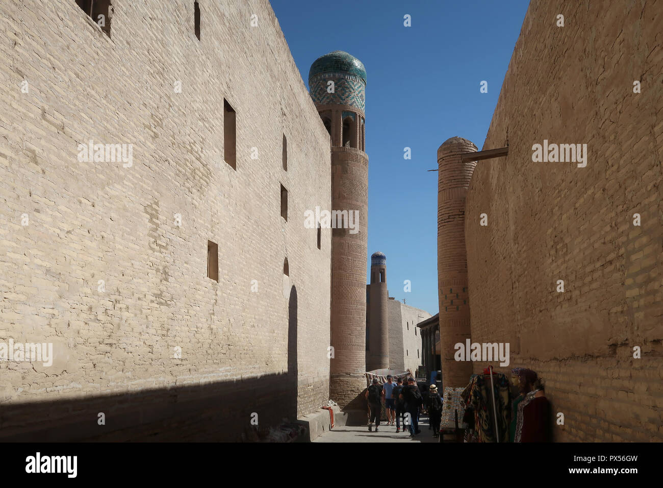 Les gens marcher dans une ruelle étroite à l'Ichan-Kala ville historique de Khiva l'ancienne capitale de Khwarezmia et le Khanat de Khiva répertorié comme site du patrimoine mondial de l'Unesco situé dans la région de l'Ouzbékistan, Xorazm Banque D'Images
