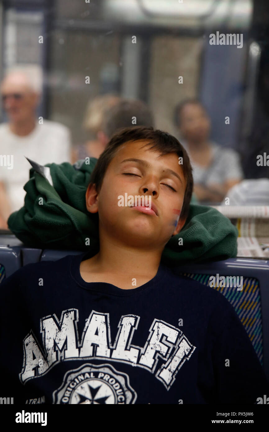 Garçon de 11 ans dormant sur le métro de Paris (France). Banque D'Images