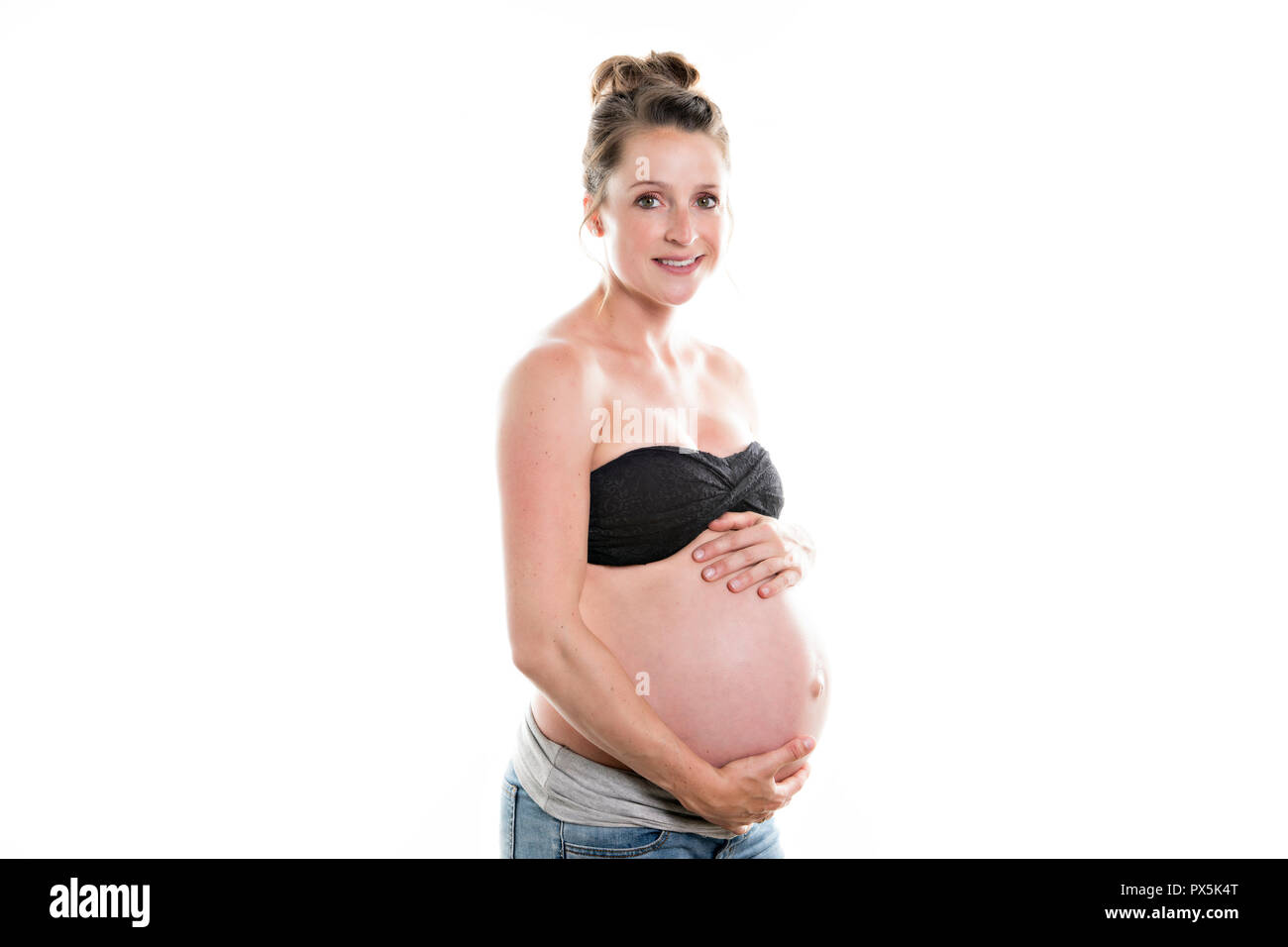 Une femme enceinte en caressant son ventre sur fond blanc Banque D'Images