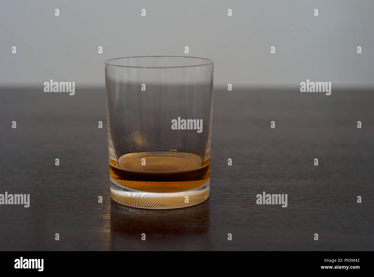 Le Scotch whisky, Bourbon, ou de rhum dans un élégant Tumbler sur une table en bois foncé Banque D'Images