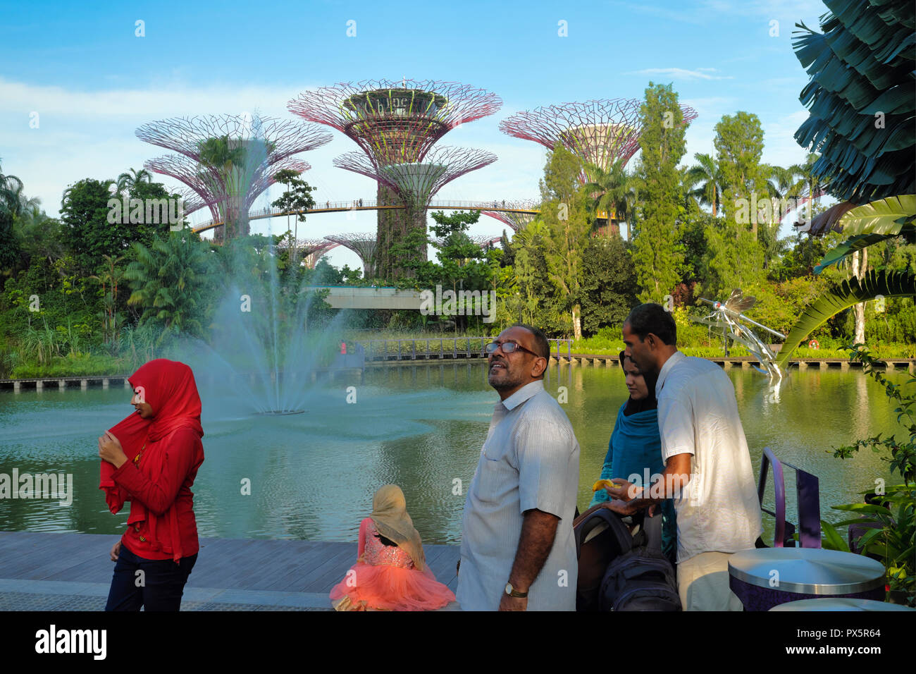 Par un étang à Gardens by the Bay à Singapour, les touristes étrangers, admirer le paysage en arrière-plan l'emblématique Super Tress Banque D'Images