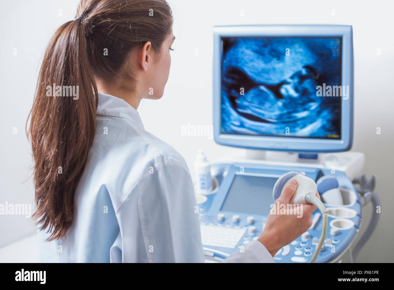 Jeune femme médecin est l'affichage d'un résultat d'ultrasons pour contrôler les signes visibles de la trisomie 21 Banque D'Images