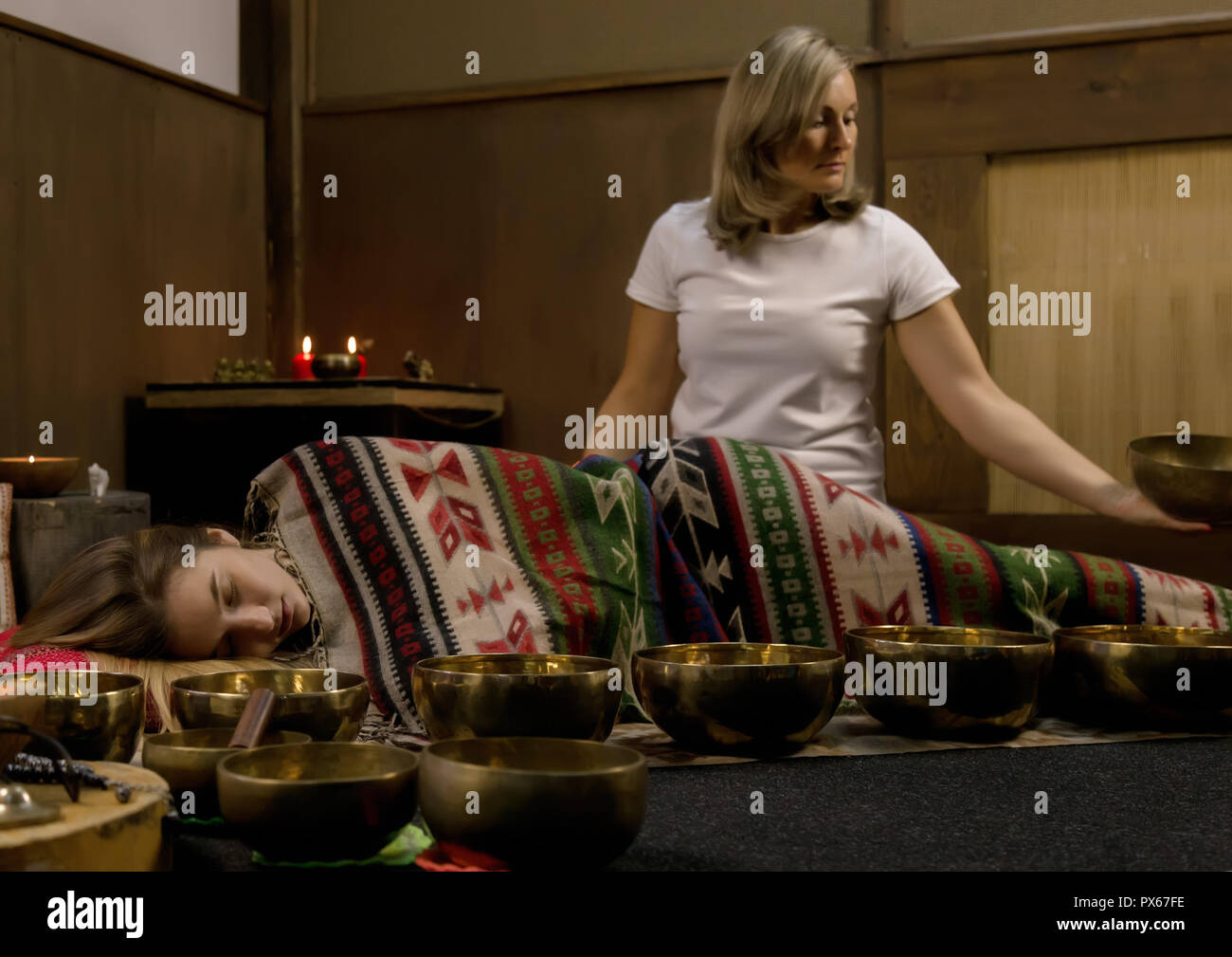 Femme avec des bols chantants tibétains. instructeur de yoga méditation mène le mouvement lent. Banque D'Images