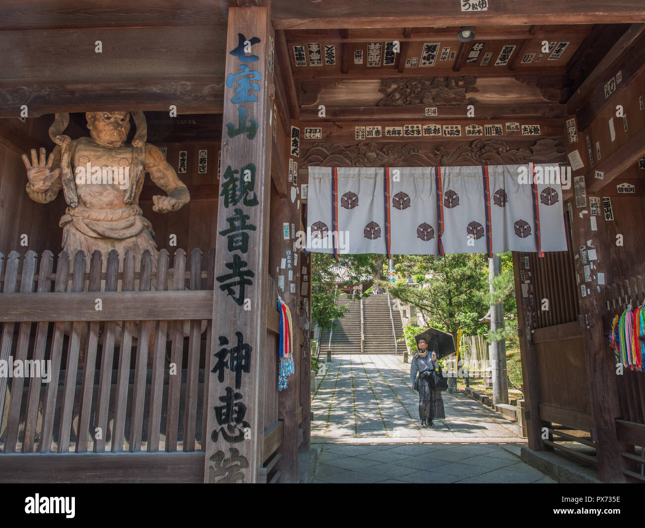Femme marche passé nio guardian, porte du temple, temple 69 Kanonji, Shikoku 88 pèlerinage temple, Kagawa, Japon Banque D'Images