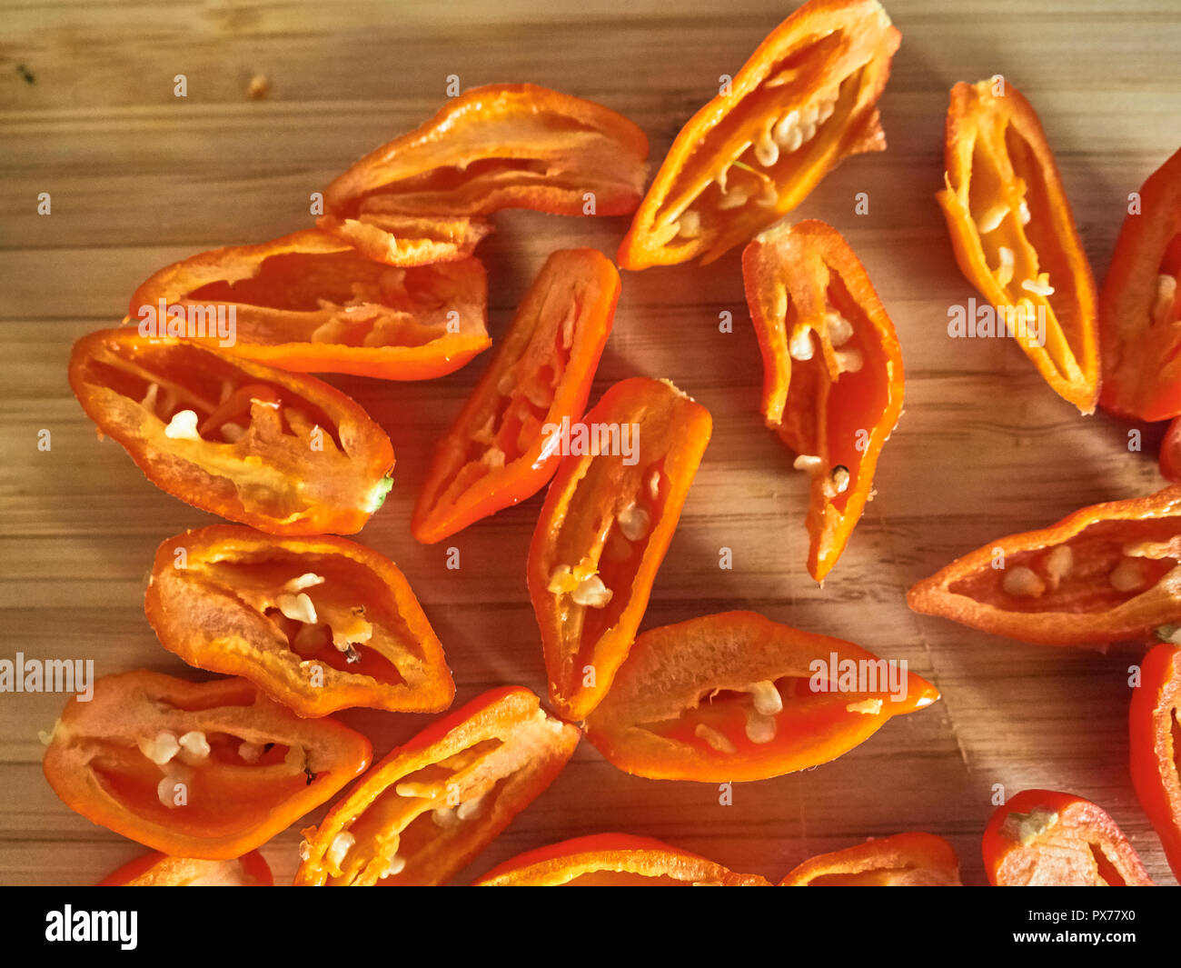 Shot de Naga Morich orange poivrons sur une planche à découper Banque D'Images