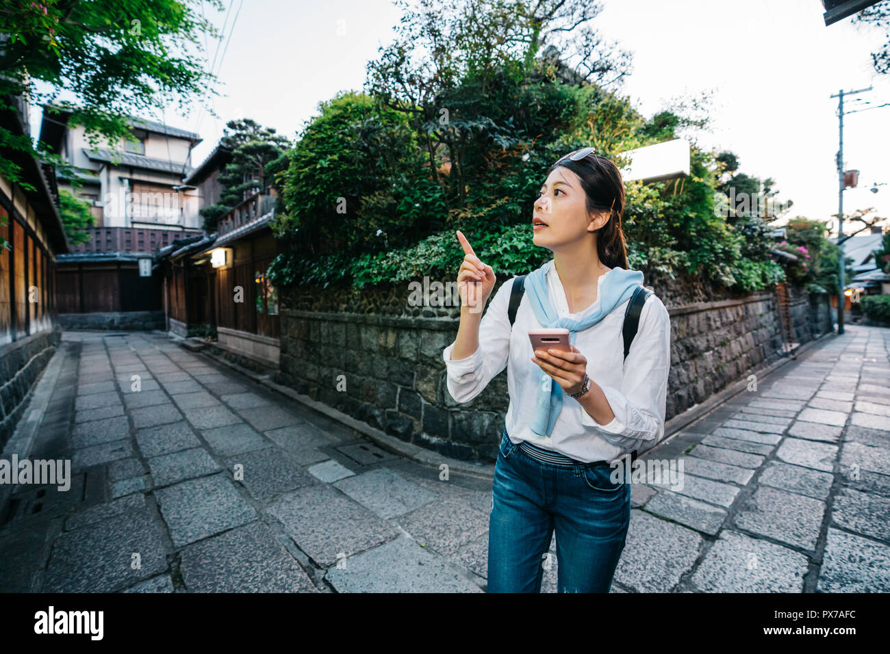 Belle dame debout sur le carrefour et compte tenu de la bonne manière. jeune voyageur en utilisant app carte en ligne pour trouver l'hôtel à Kyoto. woman Banque D'Images