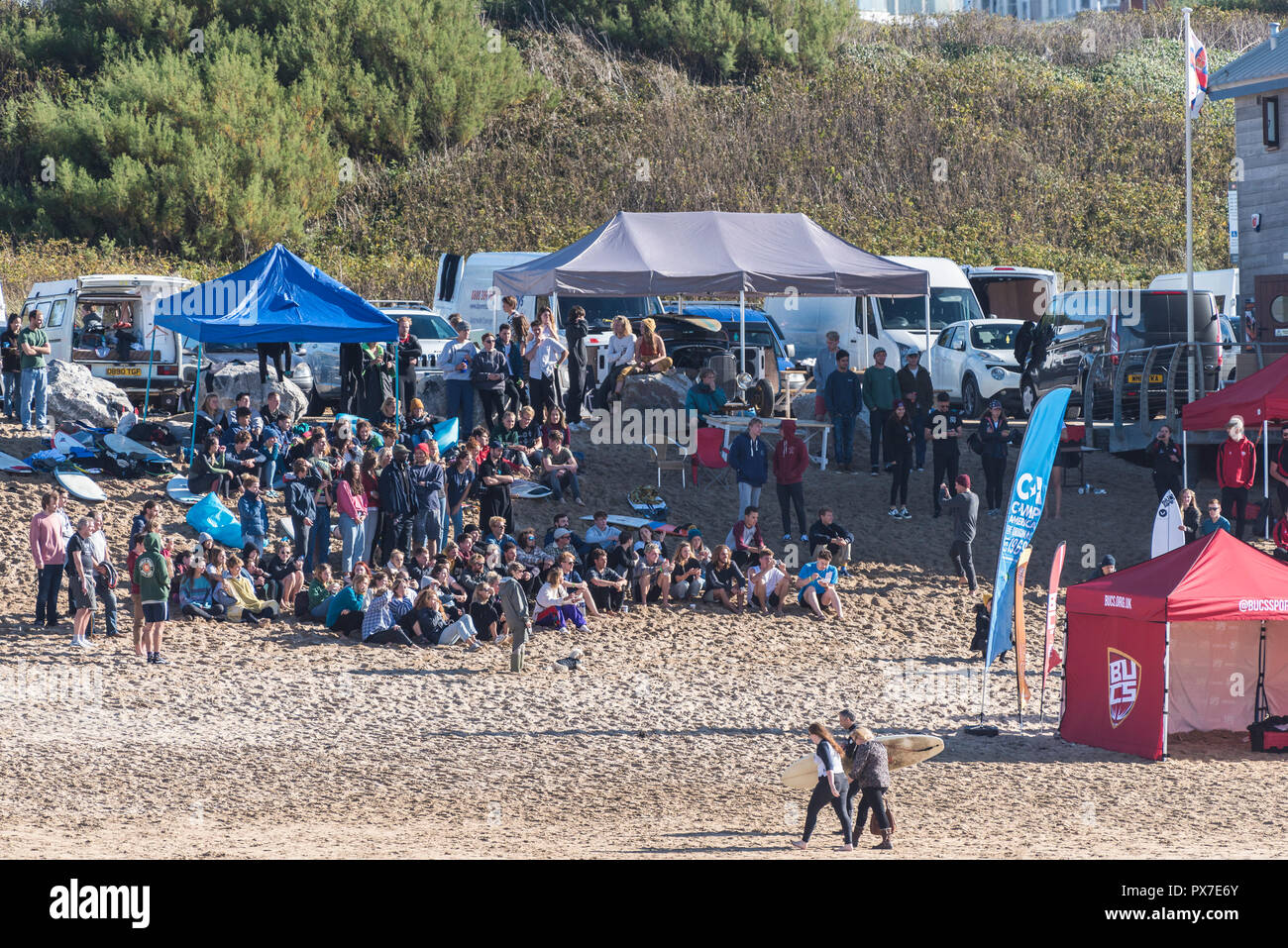 Une foule de surfeurs assis sur l'observation ; B Fistral ; chaque regardant un prix sont presnted. Banque D'Images