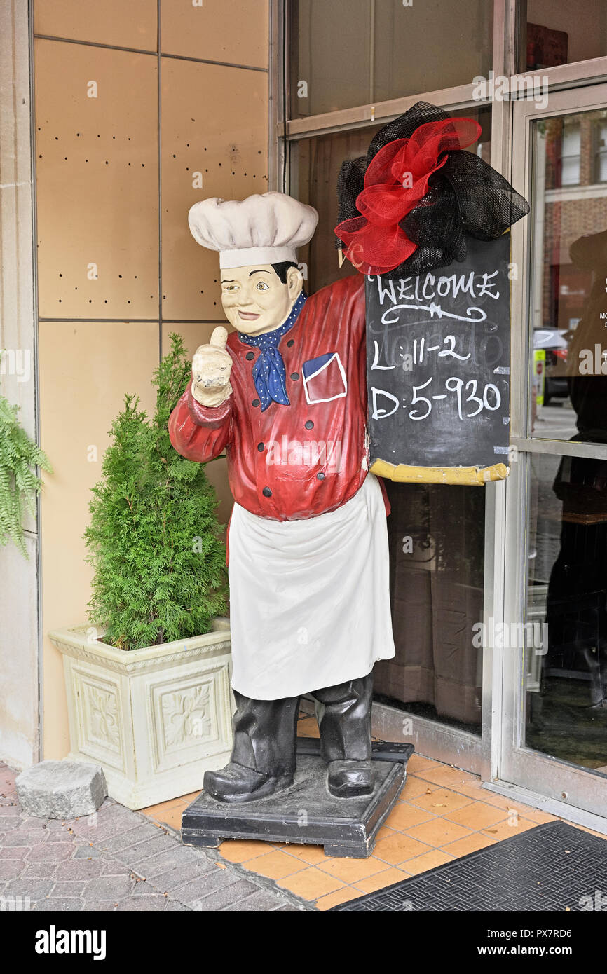 Grande statue de chef ou figure sur le trottoir tenant un restaurant sign board indiquant les heures de fonctionnement à un café à LaGrange en Géorgie, aux États-Unis. Banque D'Images